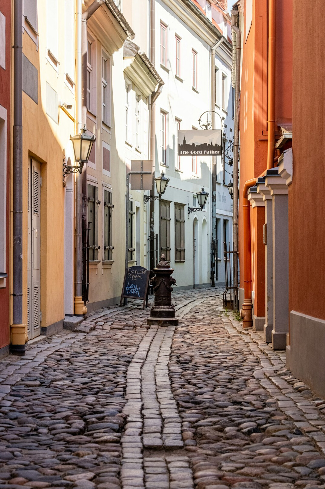 Narrow cobblestone street between historic European townhouses